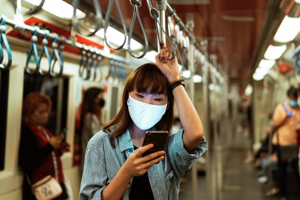 Woman wearing protective mask on public transportation.