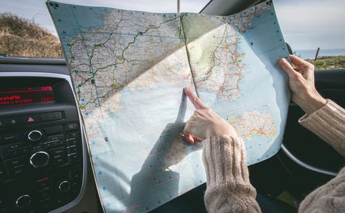 Woman pointing at map to plan out directions.