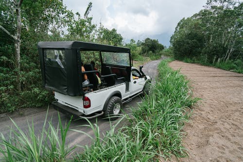 A open back truck driving down a road.